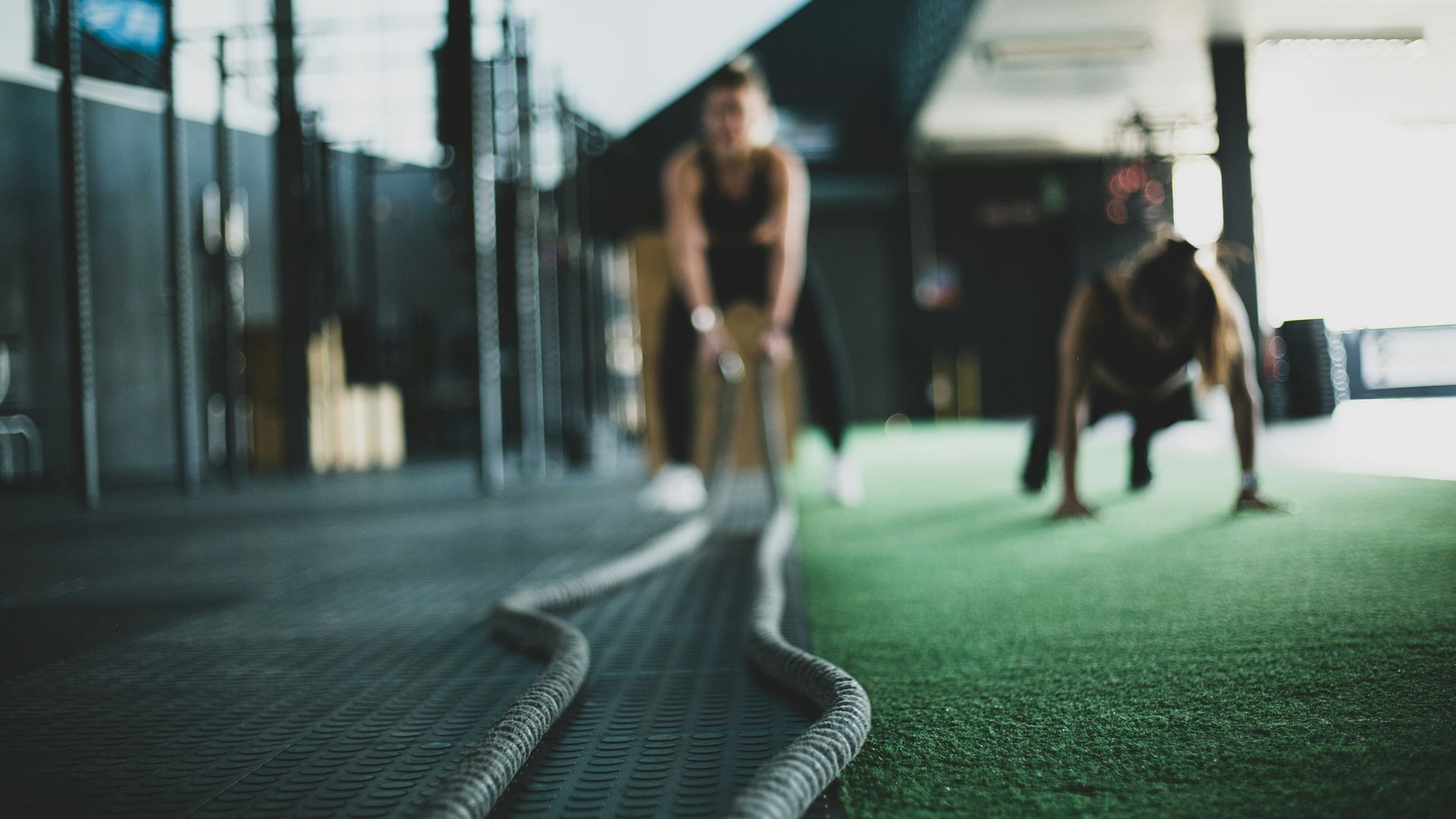 Women training with battle ropes in a gym